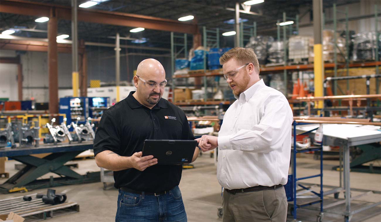 Photo of two Brandt employees working on a laptop