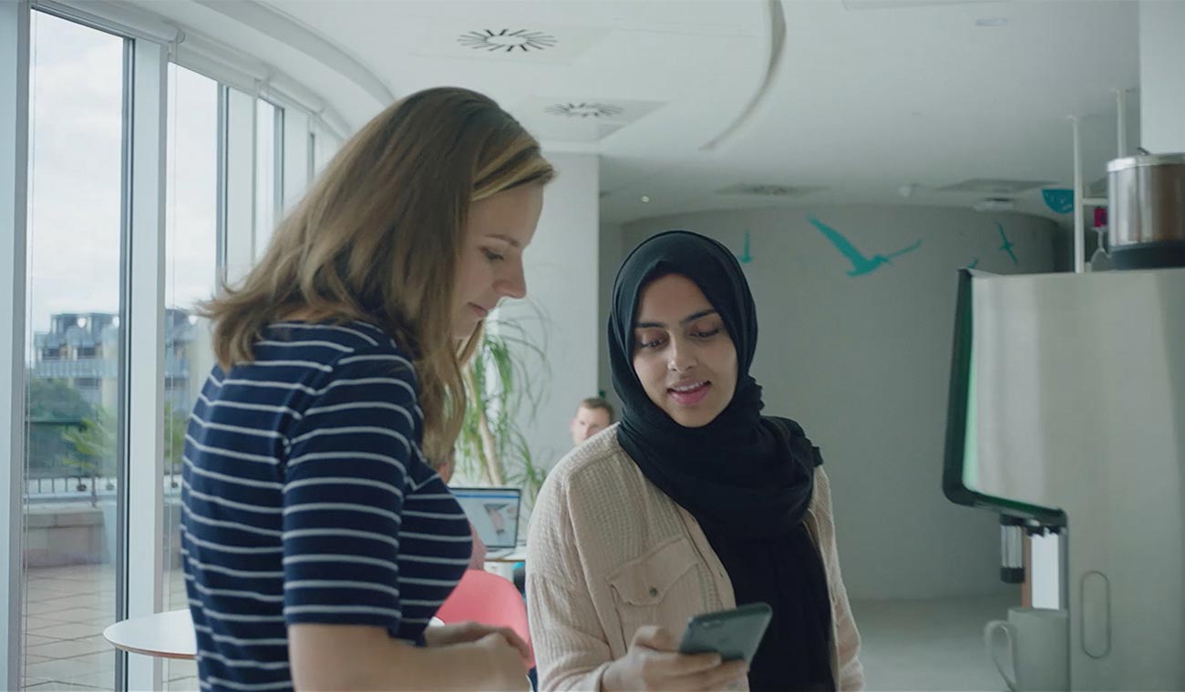 Photo of two Expedia employees looking at a phone