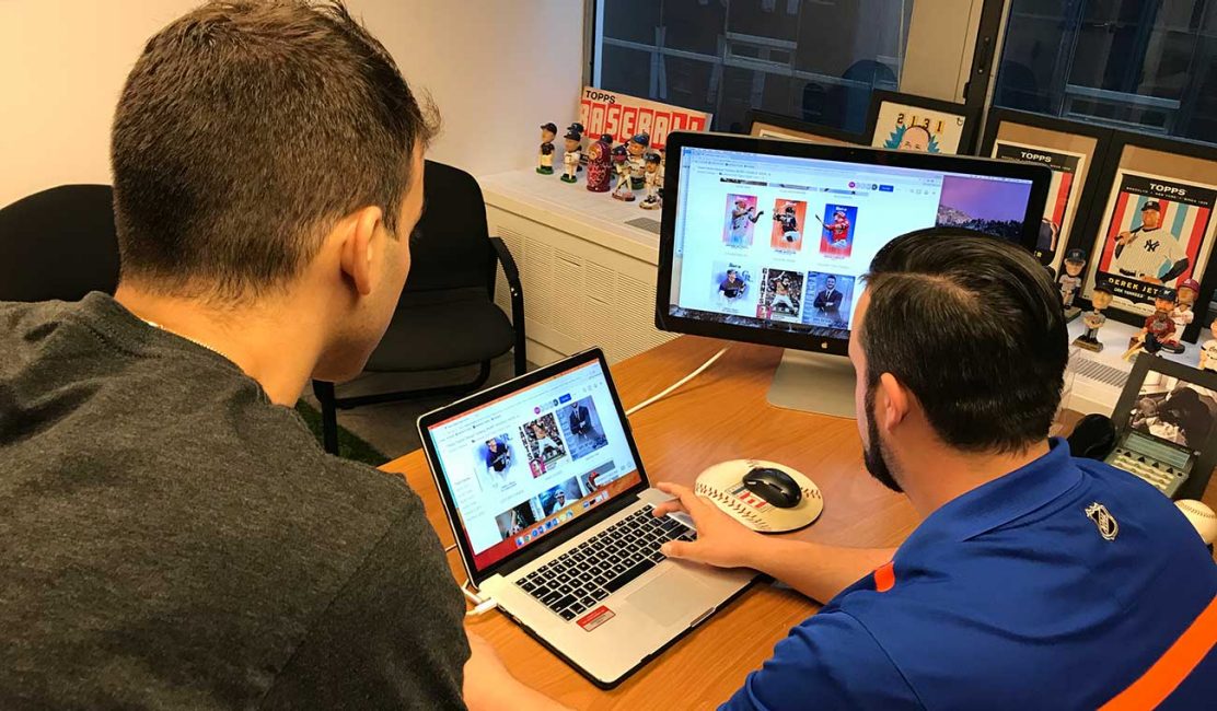 Photo of two Topps employees looking at the Dropbox website on a computer screen