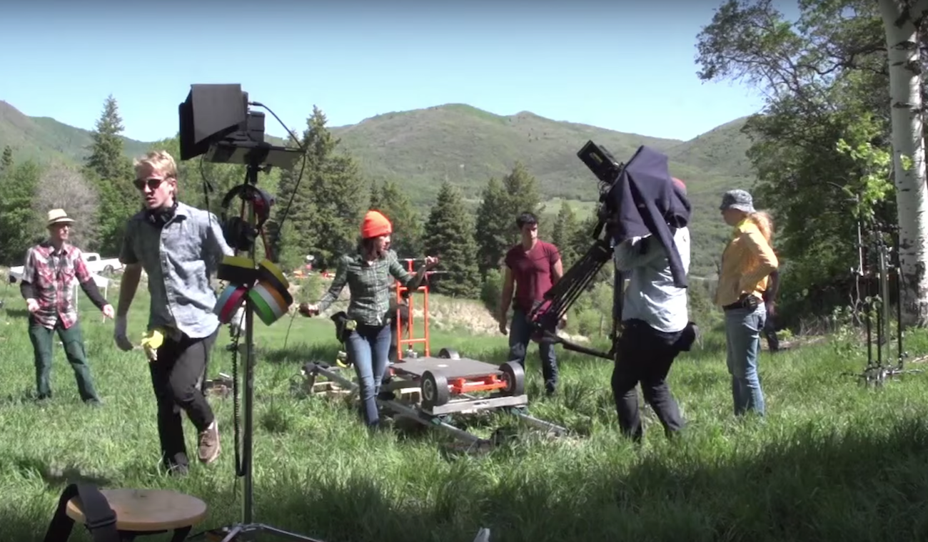 A film crew packs up equipment in an outdoor location