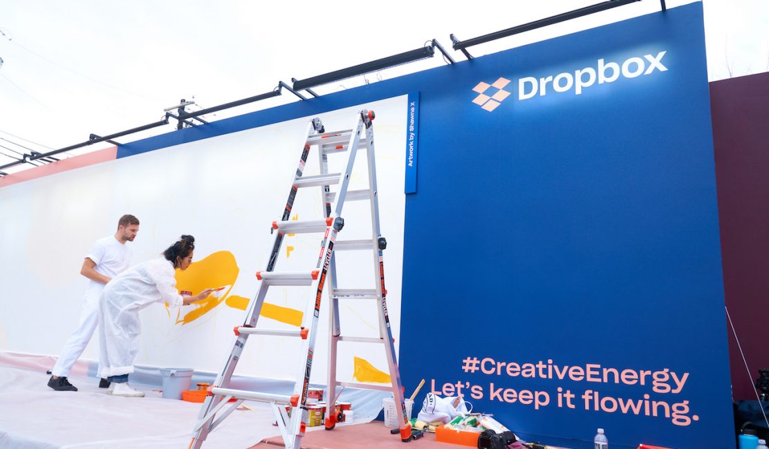 Photo of artists working on a Dropbox mural at SXSW 2018