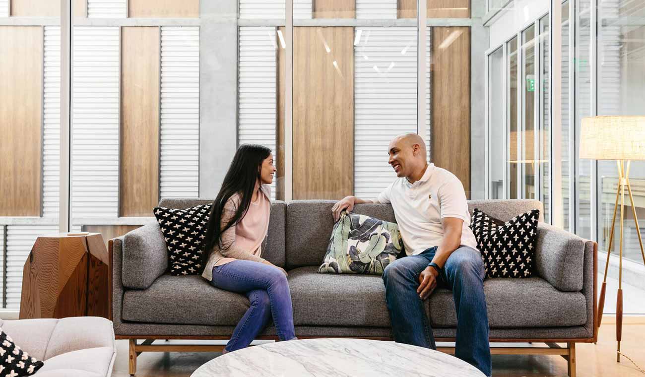 Photo of two people sitting on a couch in an office