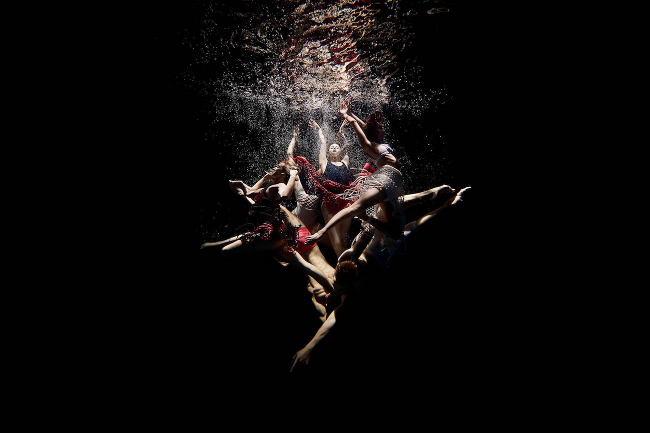 A photo of ballet dancers underwater