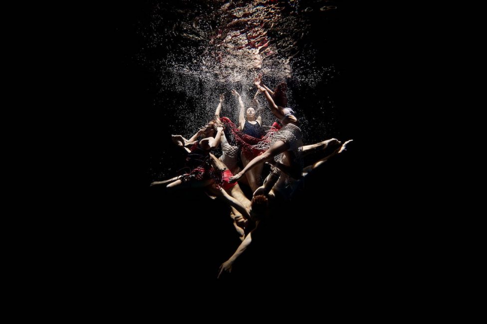 A photo of ballet dancers underwater