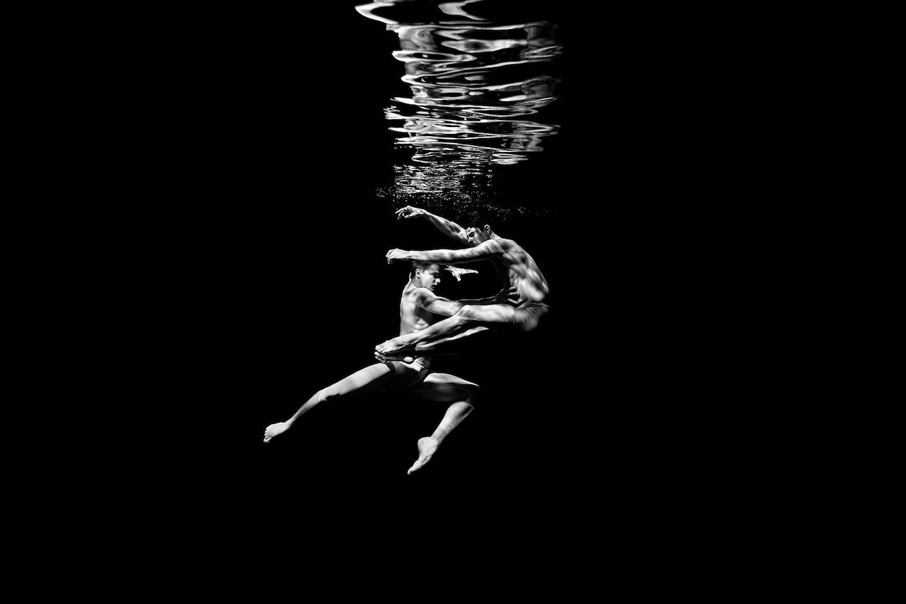 A photo of ballet dancers underwater