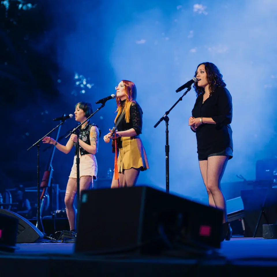 Photo by Grace Brown of Bess Rogers and Allie Moss on stage with Ingrid Michaelson