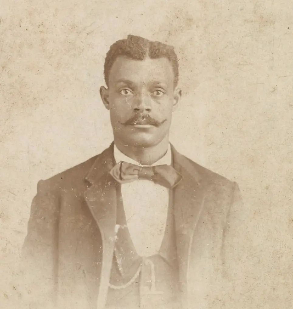 Studio portrait of a man with a handlebar mustache and bow tie