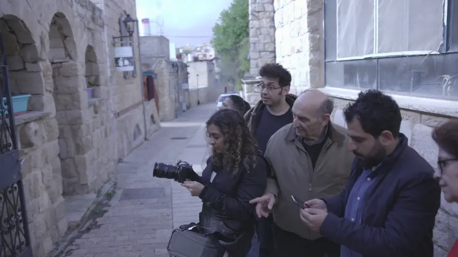 Family watching woman work with camera