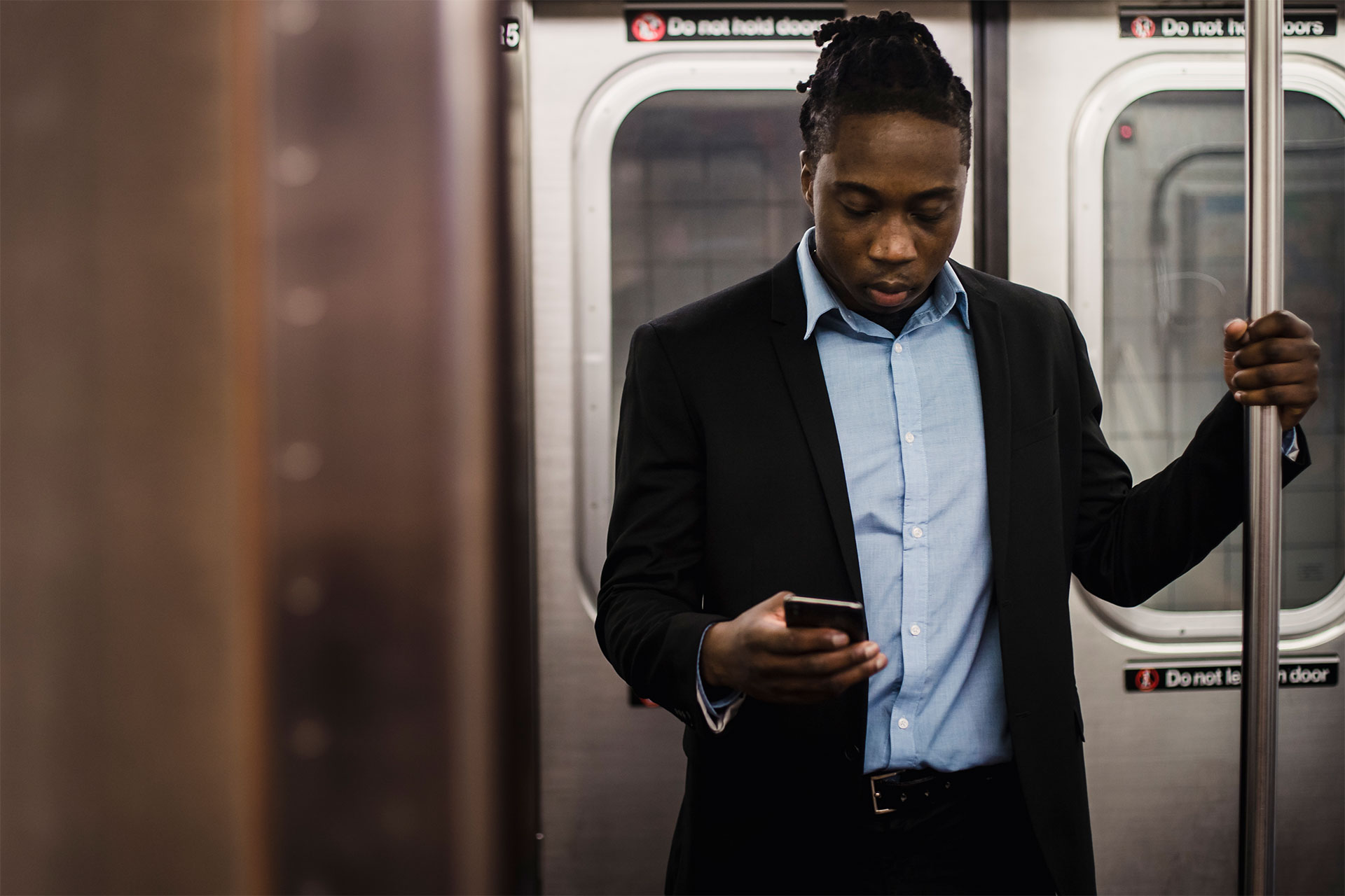 A person doing work on a phone while on the subway