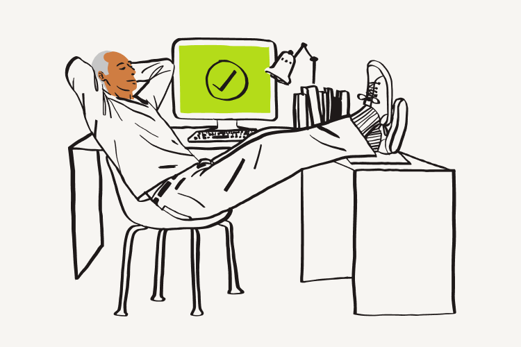 Hombre inclinándose sobre su escritorio con una gran marca de verificación verde en su pantalla 