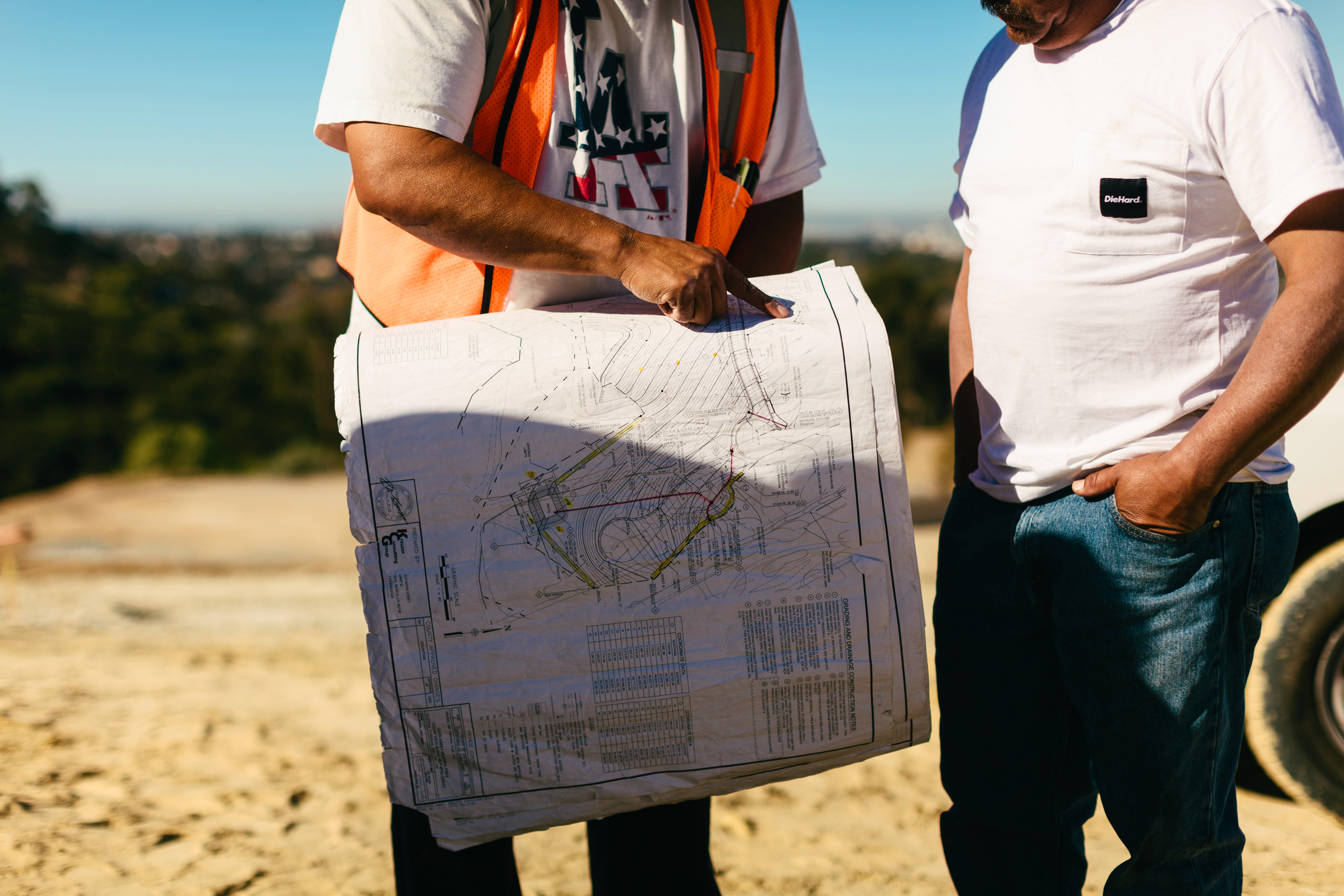 Construction workers looking and pointing at a blueprint
