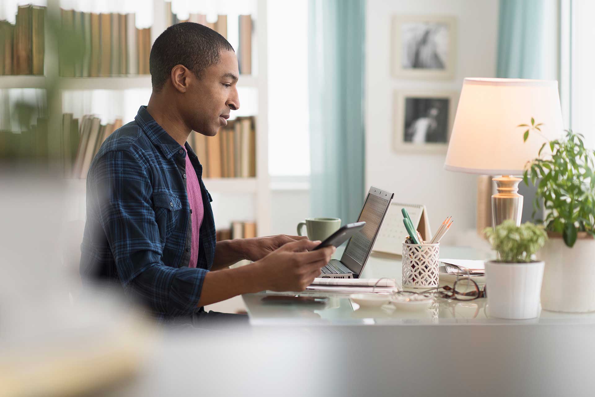 Man sitting at desk, looking at laptop