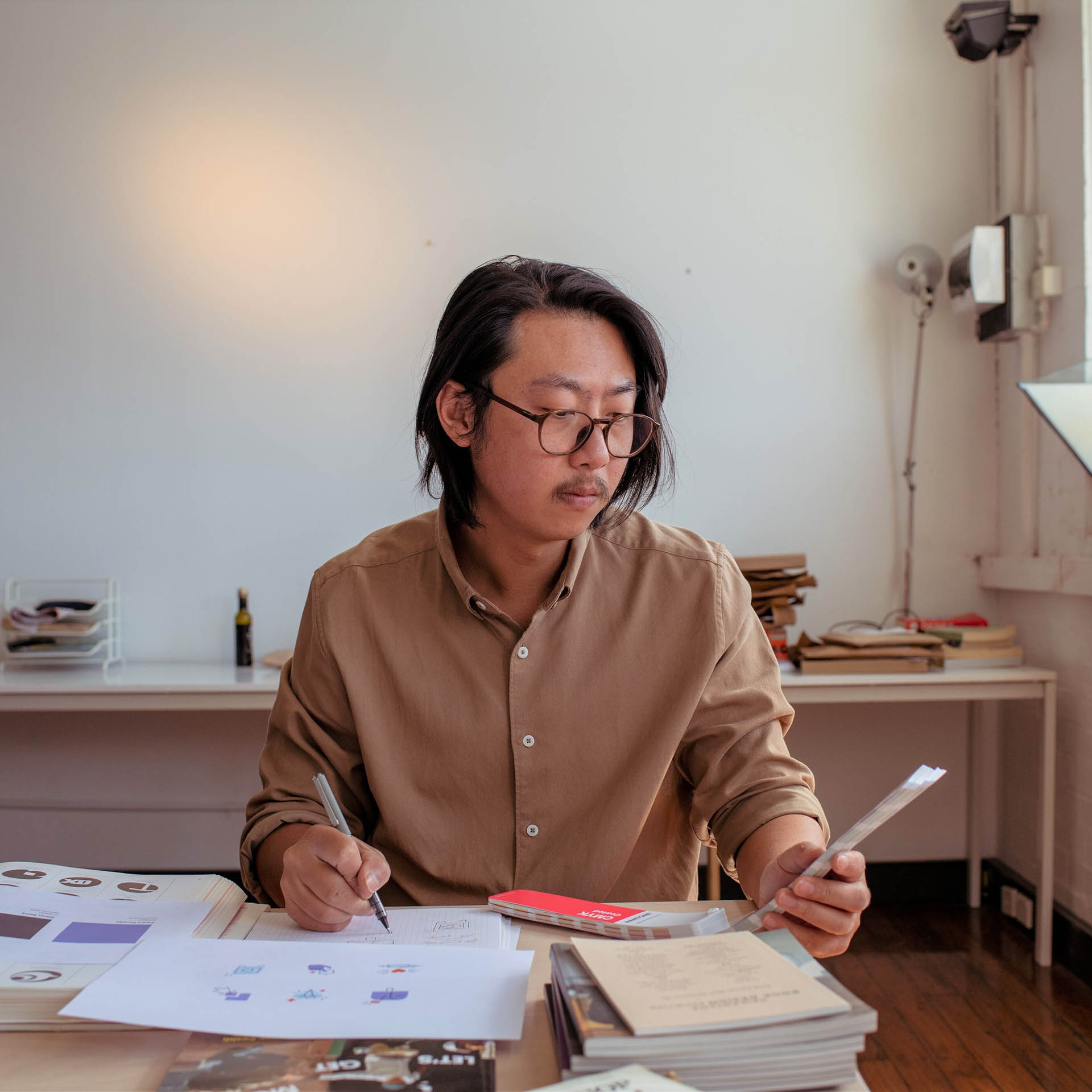 Man sits at desk looking at colour swatches