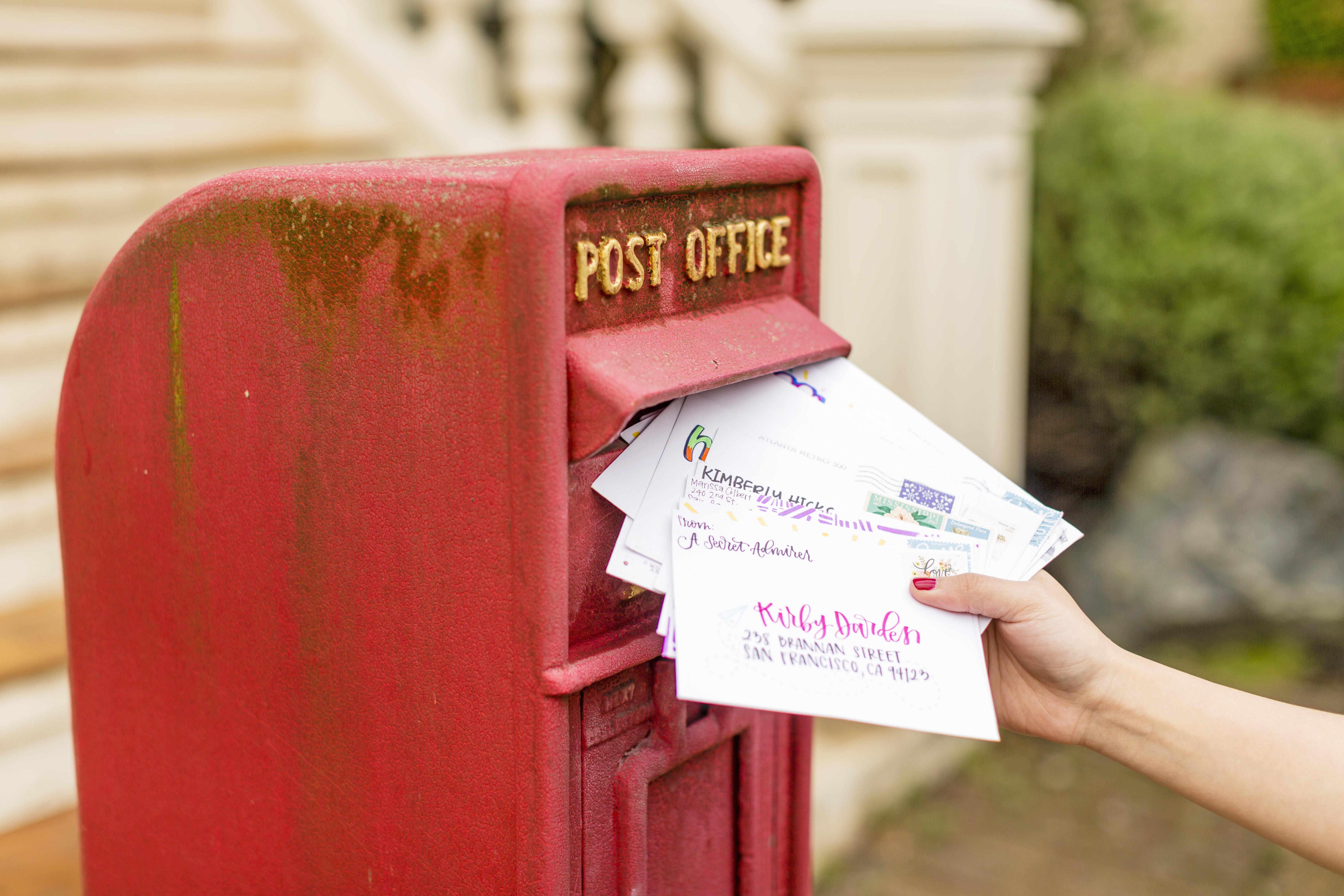 Photo of colourful greetings cards being dropped into a postbox