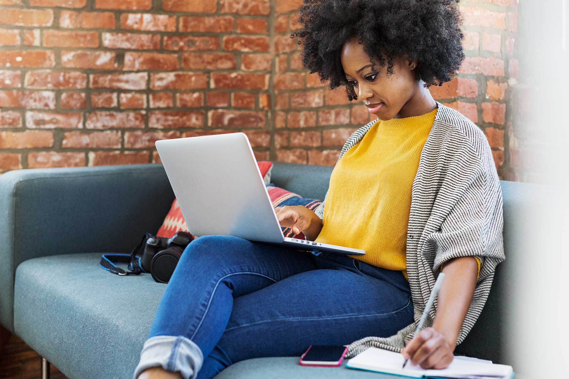 Woman sitting on sofa looking at laptop screen