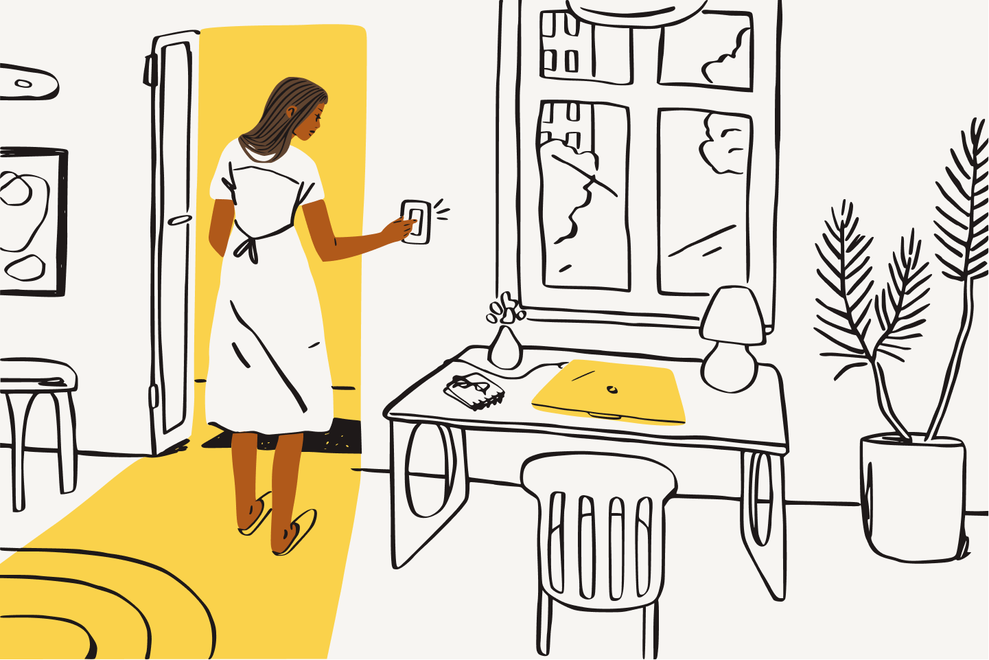 En kvinna tänder en lampa i sitt hemmakontor