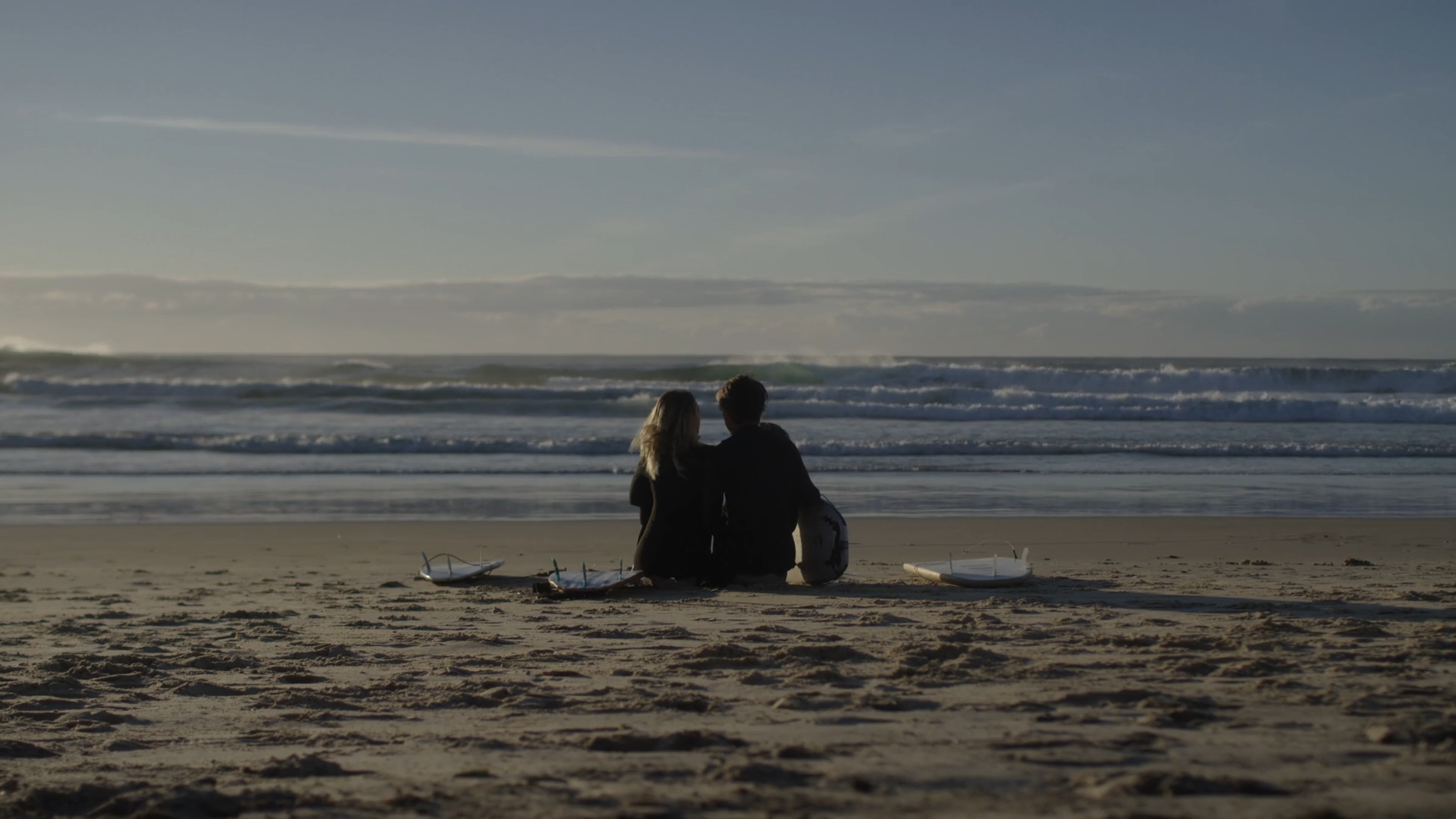 two people sitting on the beach