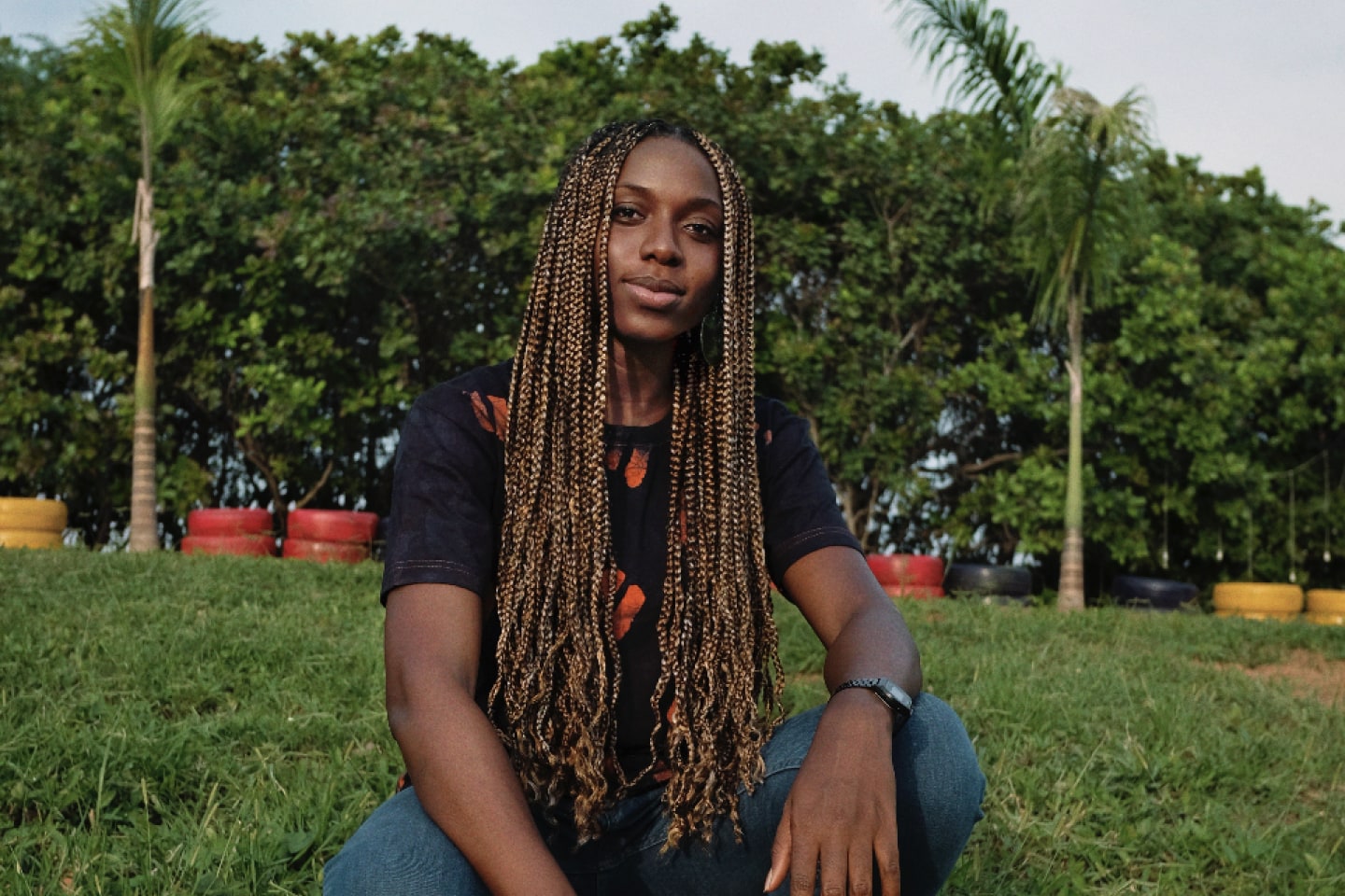 Benita Nnachortam sits in a field.