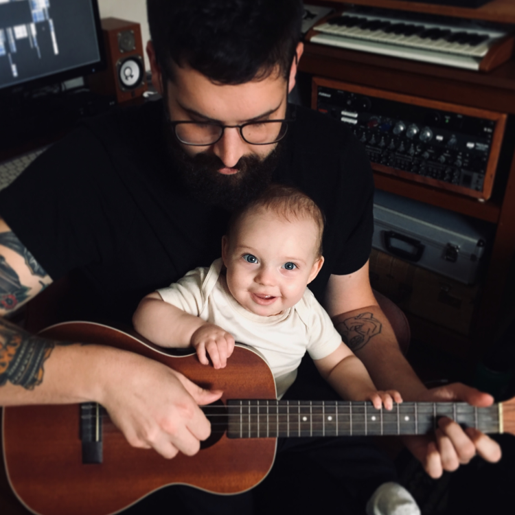 man plays guitar with baby