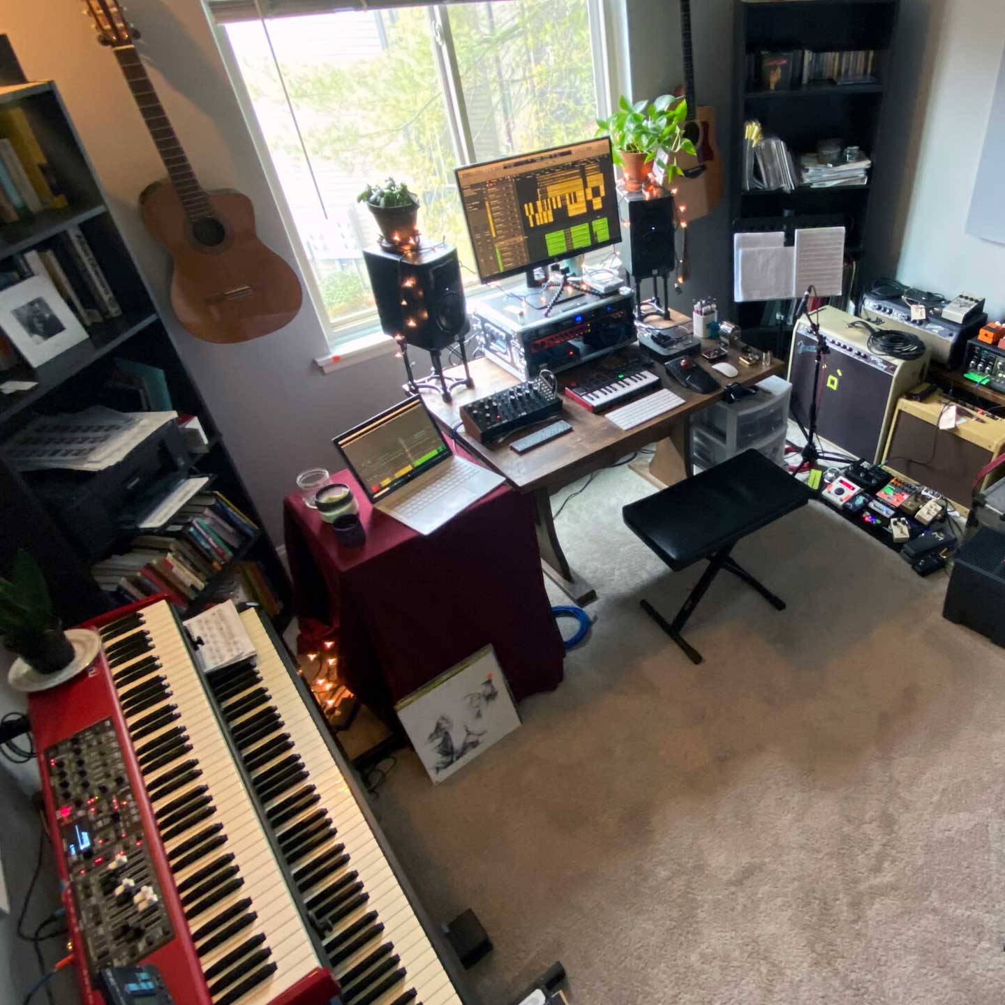 Un estudio en casa con un teclado, amplificadores y otros dispositivos para crear música.