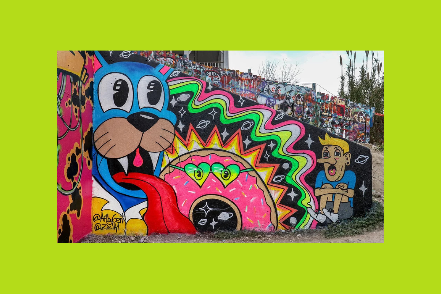 Muro artístico con un grafiti de un gato de estilo neón, un dónut y una persona.
