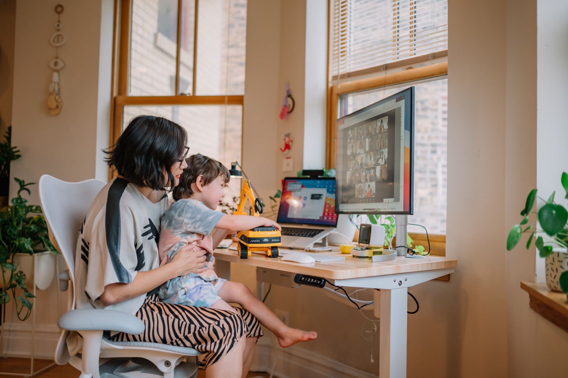 Liz Gilmore, Creative Director of Brand Studio at Dropbox, works remotely with her son while attending a Zoom meeting
