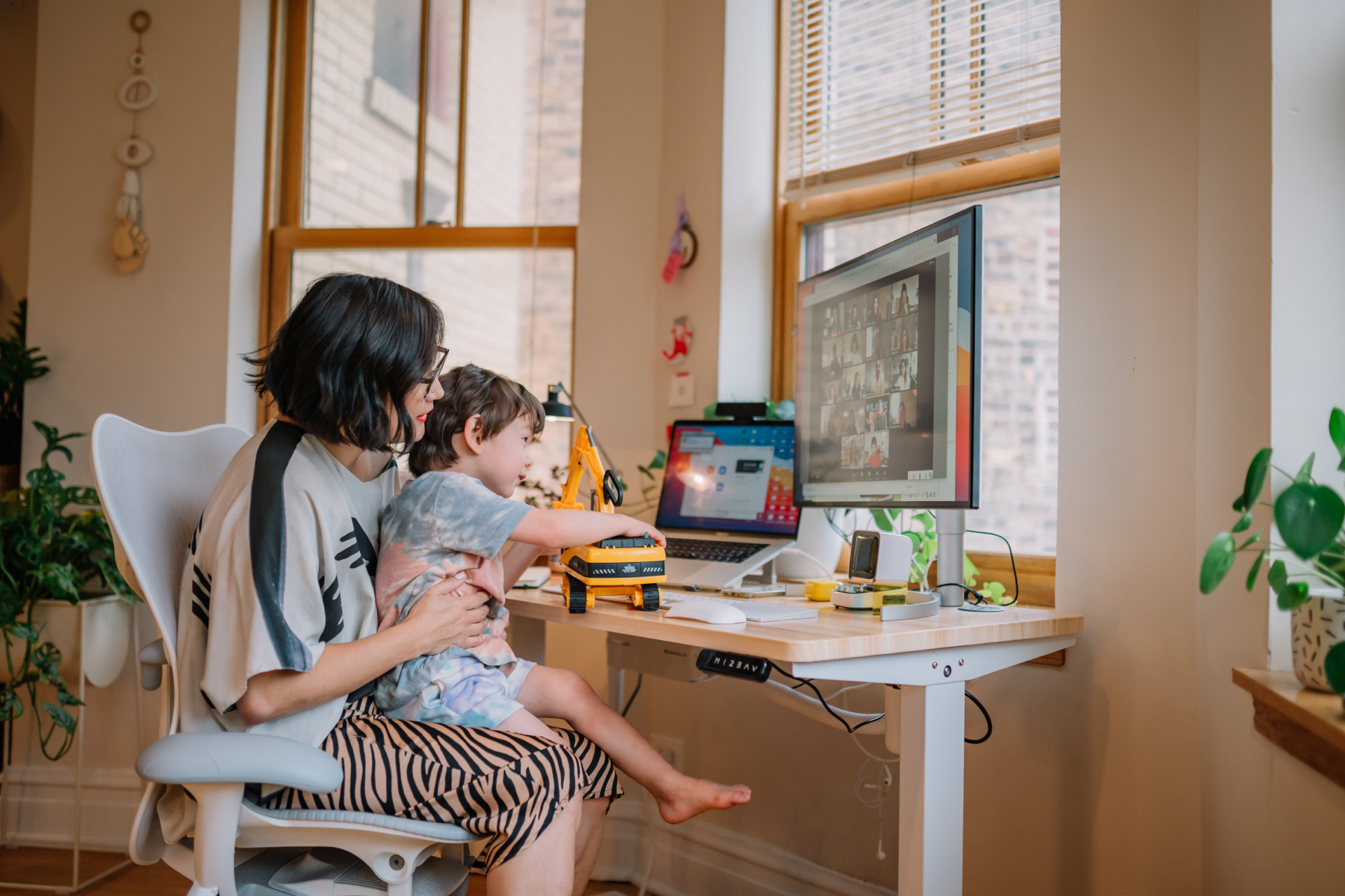 A person sits with a child on their lap at a desk