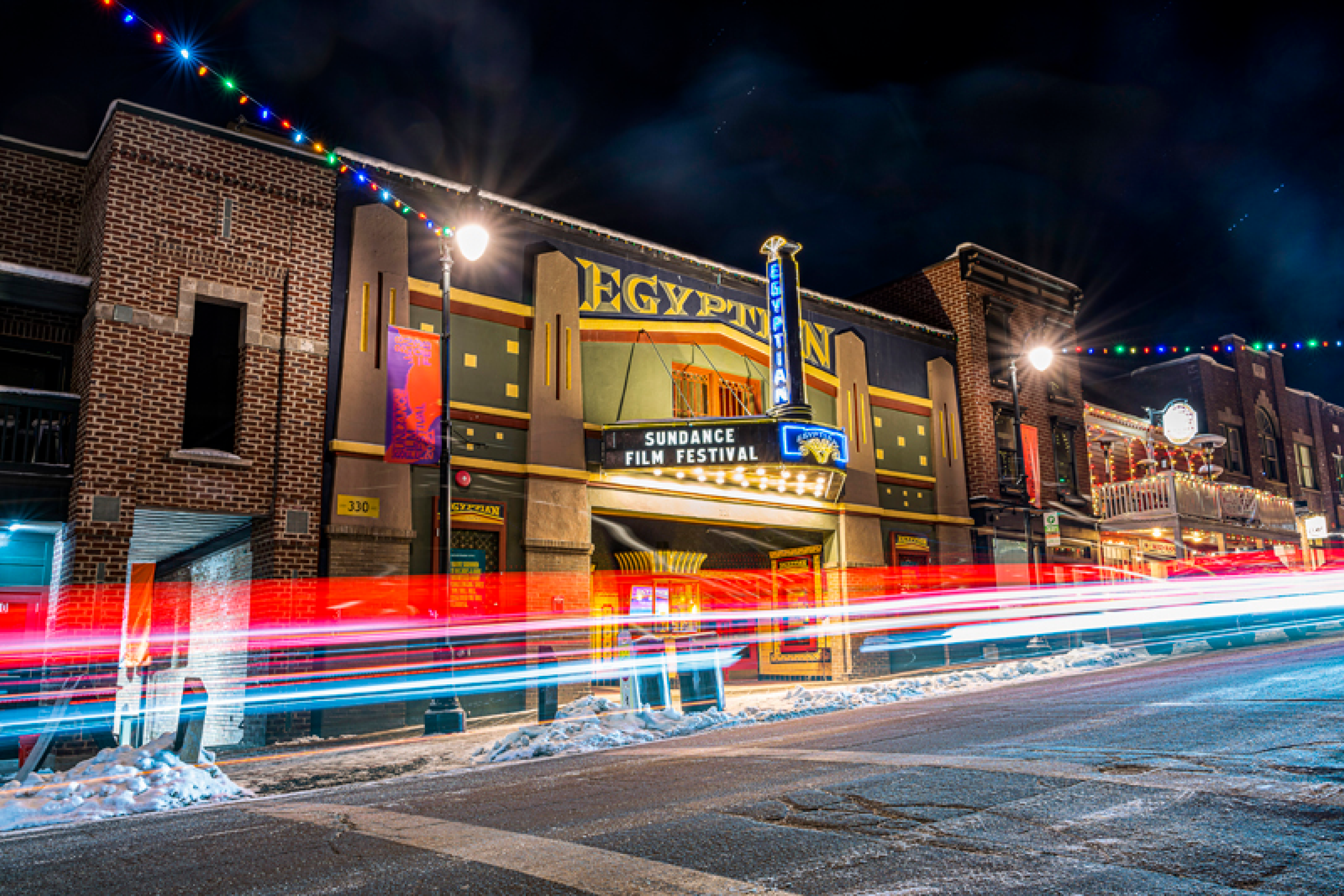 Verschneite Straße bei Nacht mit dem Werbeschild eines Kinos für Sundance 2021