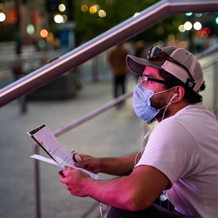 man with mask sitting with clipboard