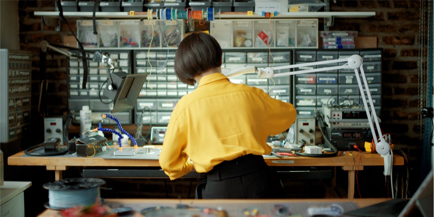 a woman standing at a desk working on some engineering 