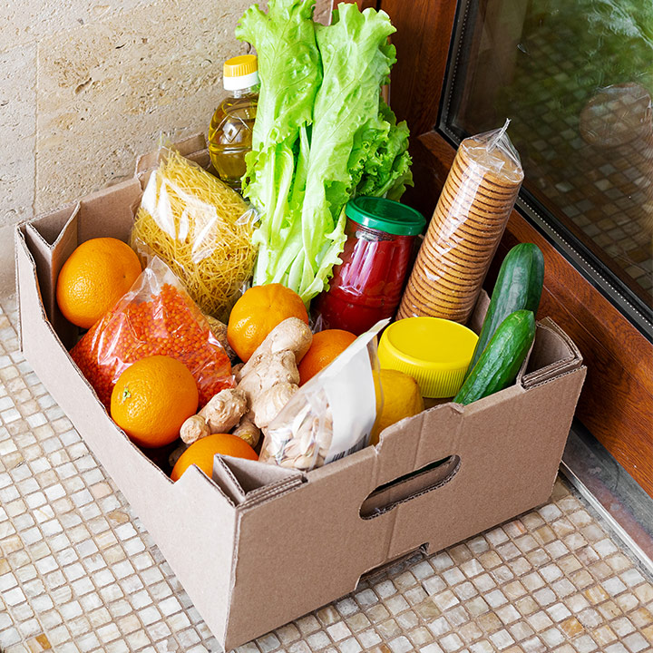 Sebuah kotak kardus berisi bahan makanan di lantai