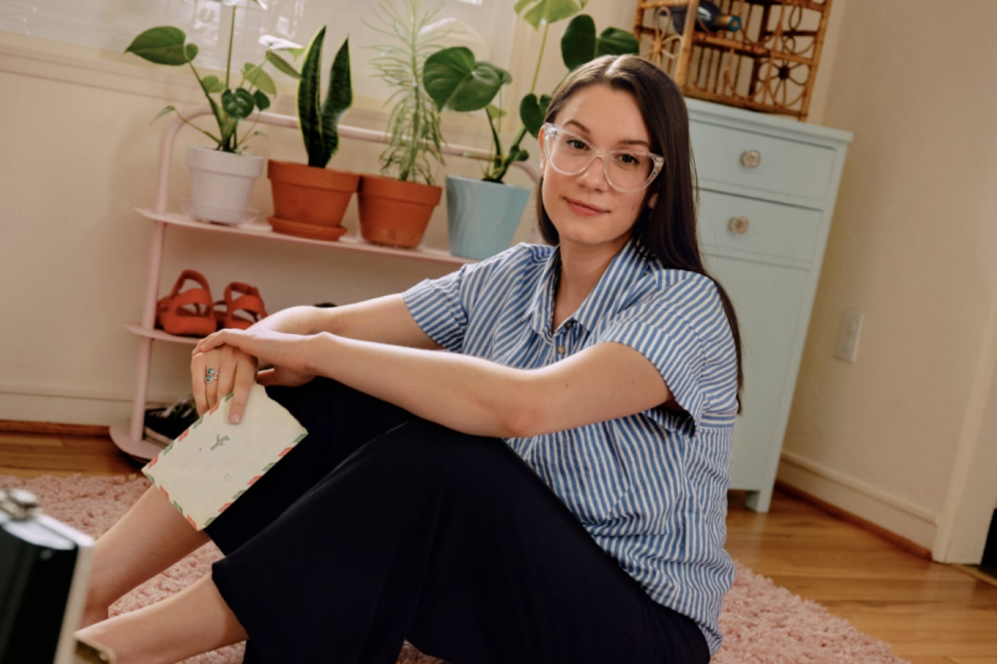Dominique King, una graphic designer, seduta sul pavimento della sua stanza.