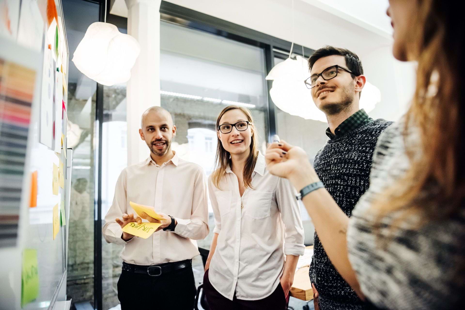 group talks at a whiteboard