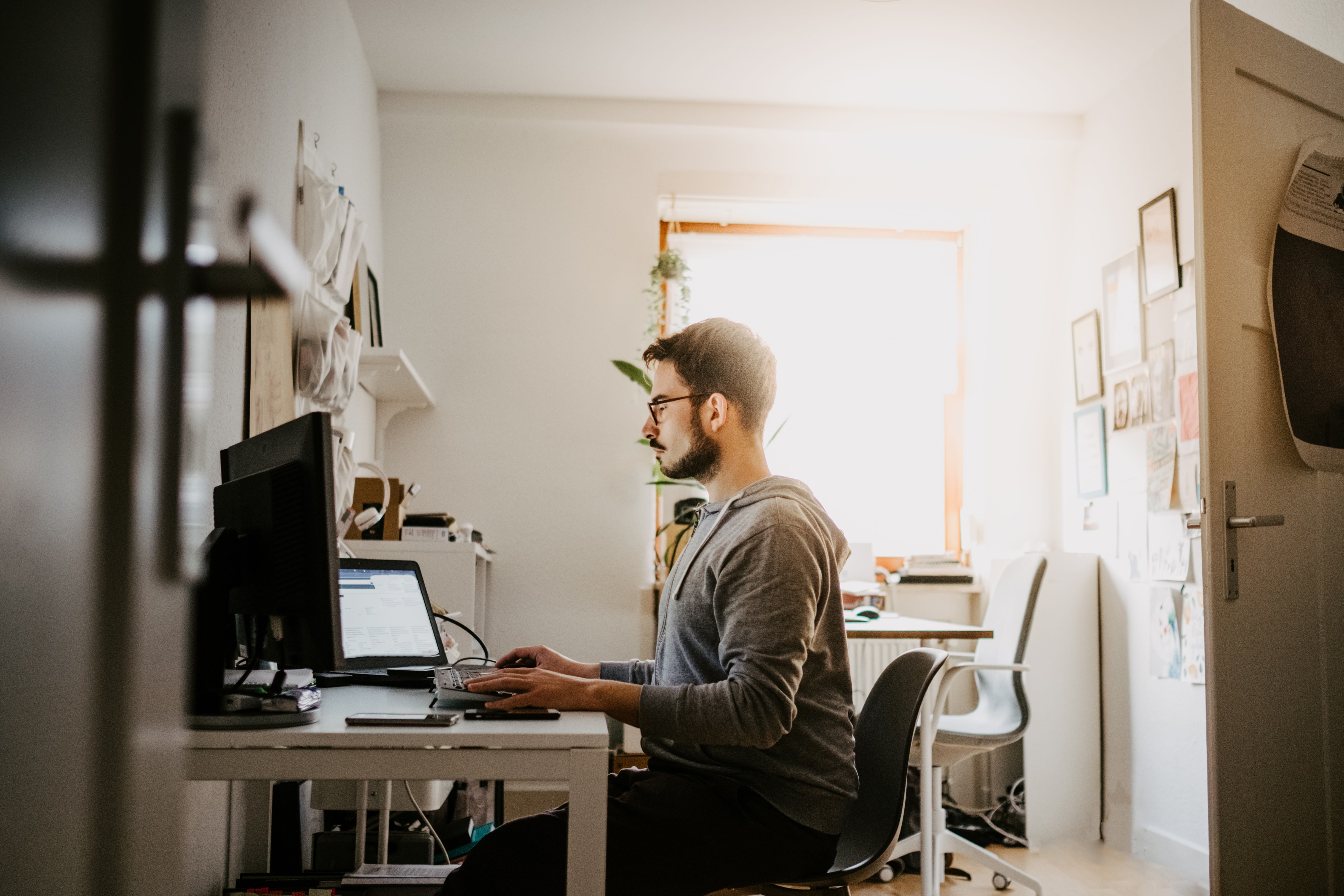  En medarbejder, der arbejder ved sin computer på sit hjemmekontor.