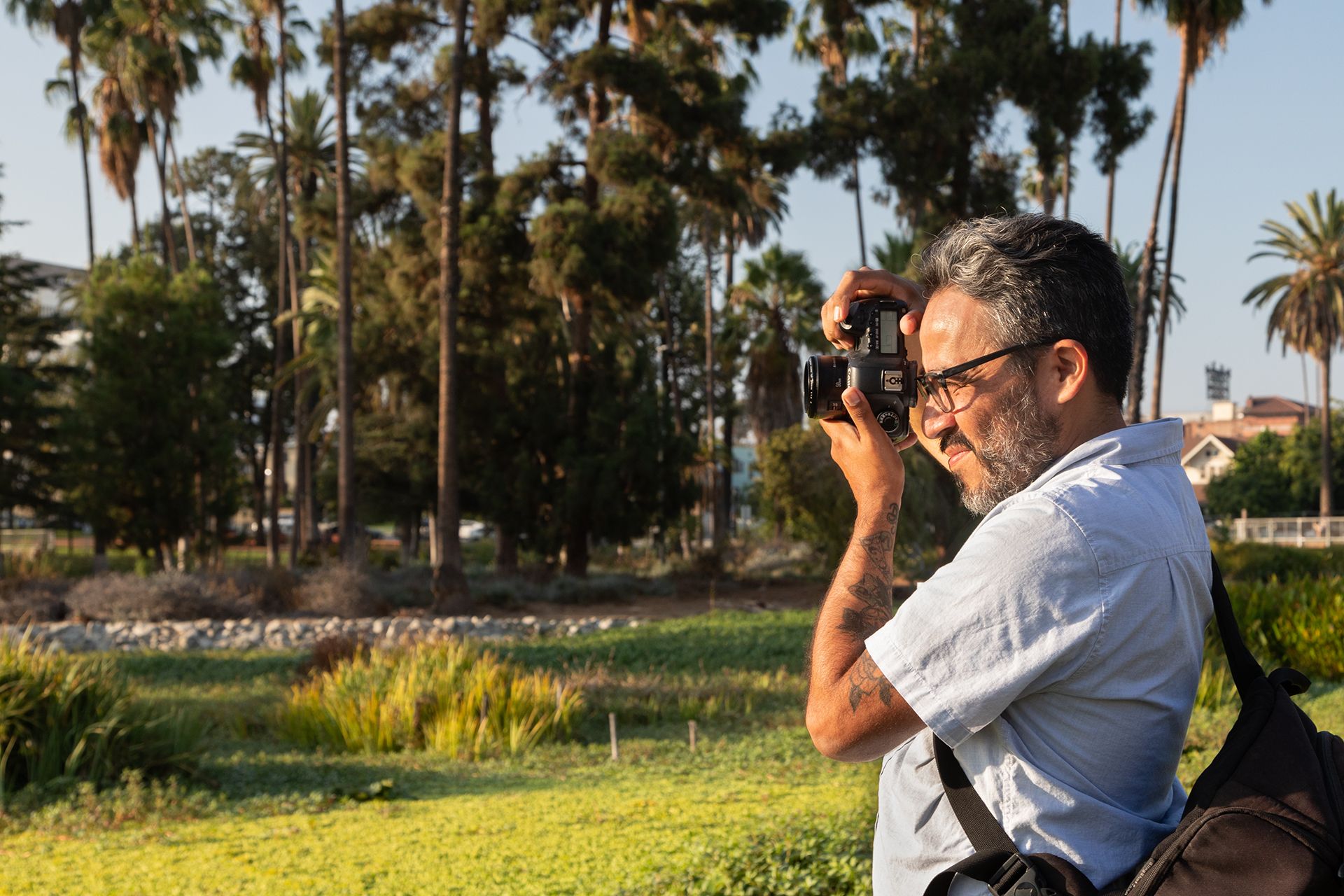 Persona sosteniendo una cámara réflex digital para sacar una foto en el exterior