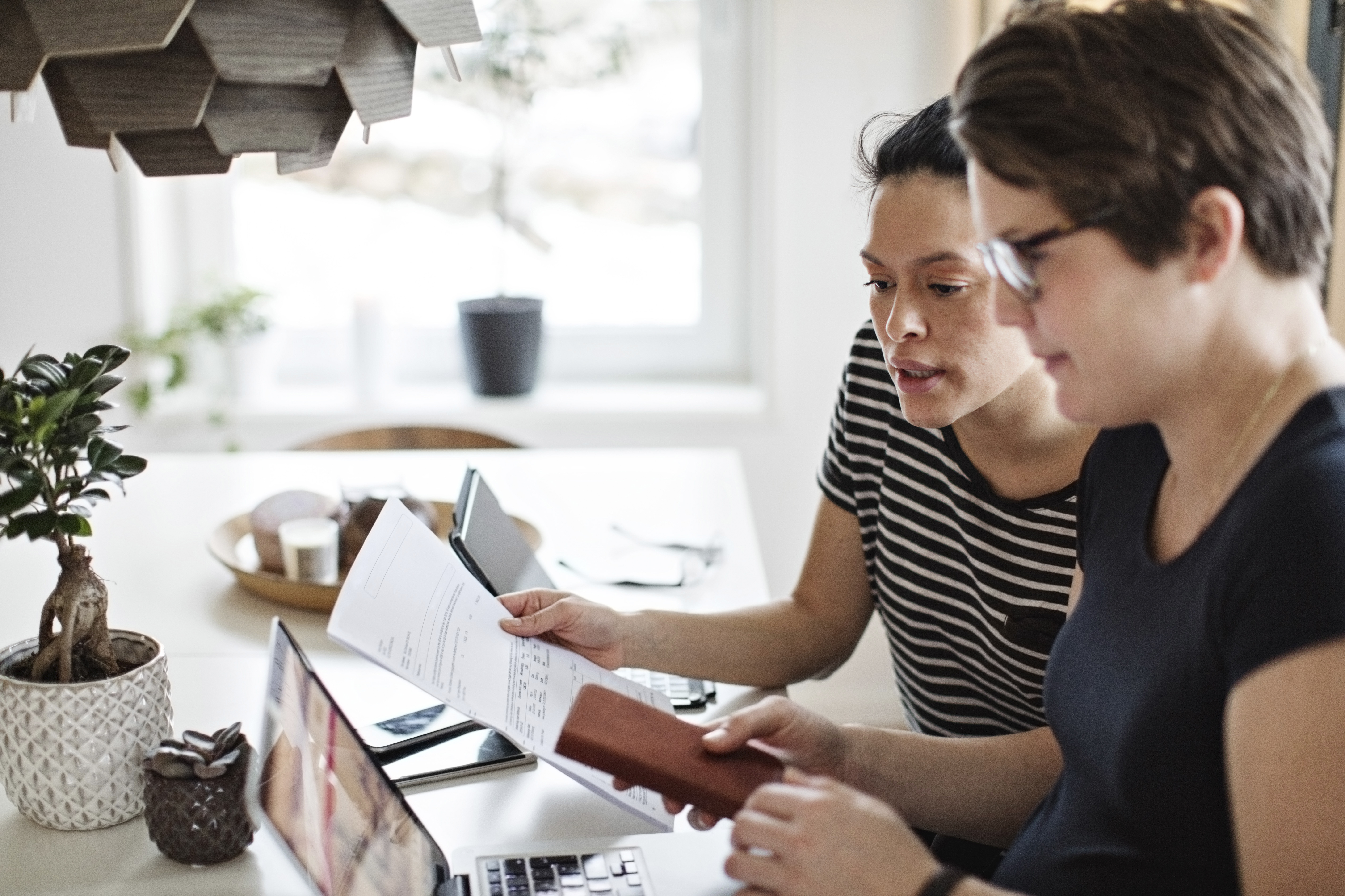 Two professionals look over an invoice.