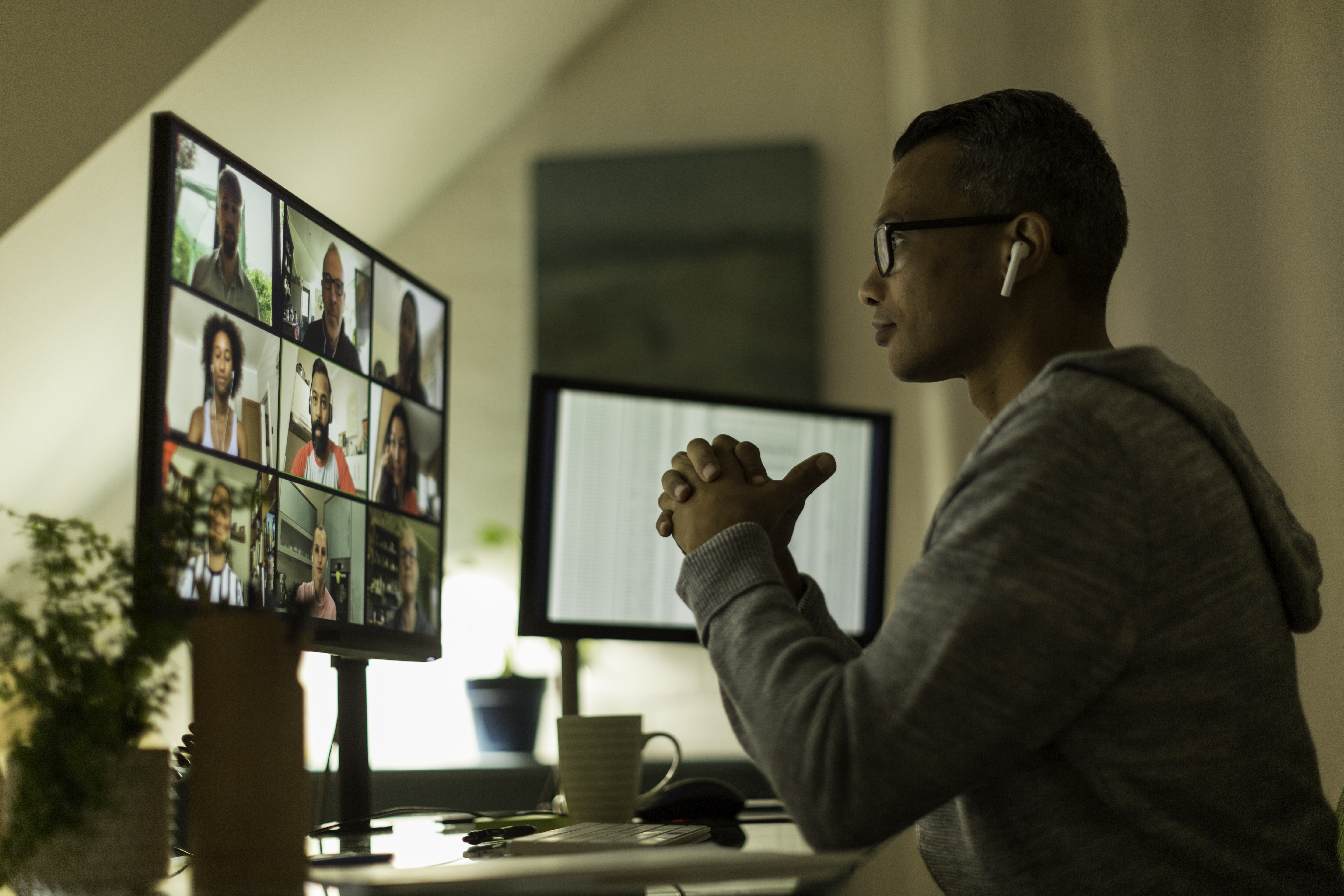 Ein Remote-Mitarbeiter blickt bei einem virtuellen Meeting auf seinen PC-Bildschirm.