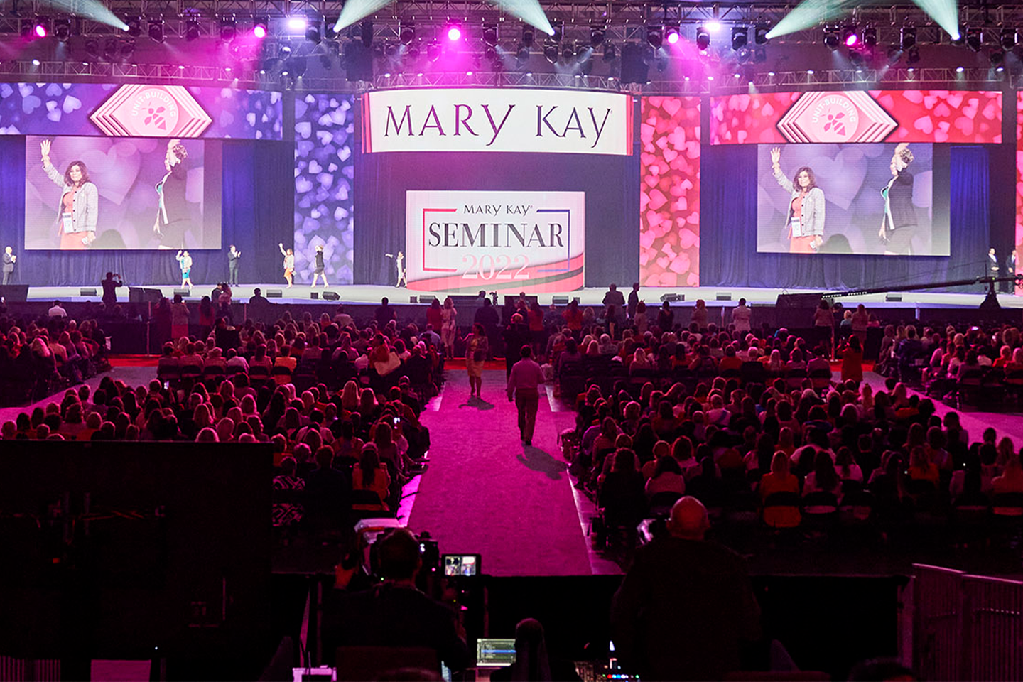 งานสัมมนาของ Mary Kay ที่มีผู้คนกำลังเดินผ่านเวที