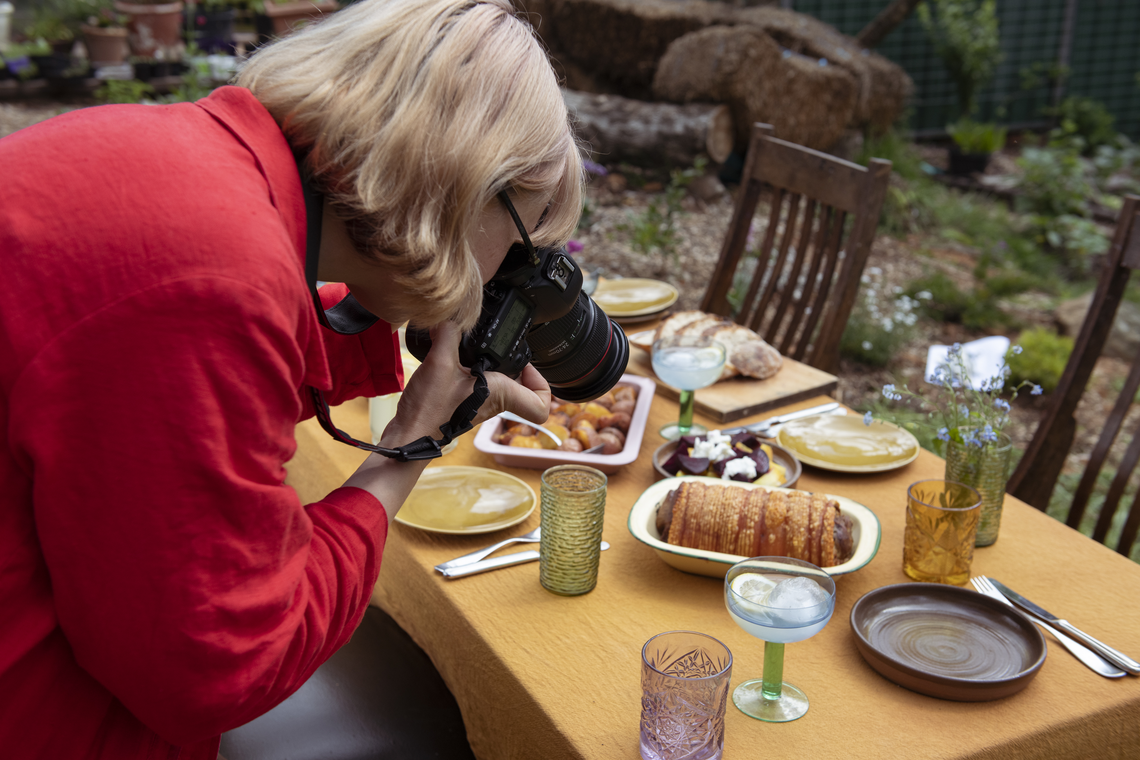 Ein Fotograf macht eine Aufnahme von einem Tisch mit Essen.