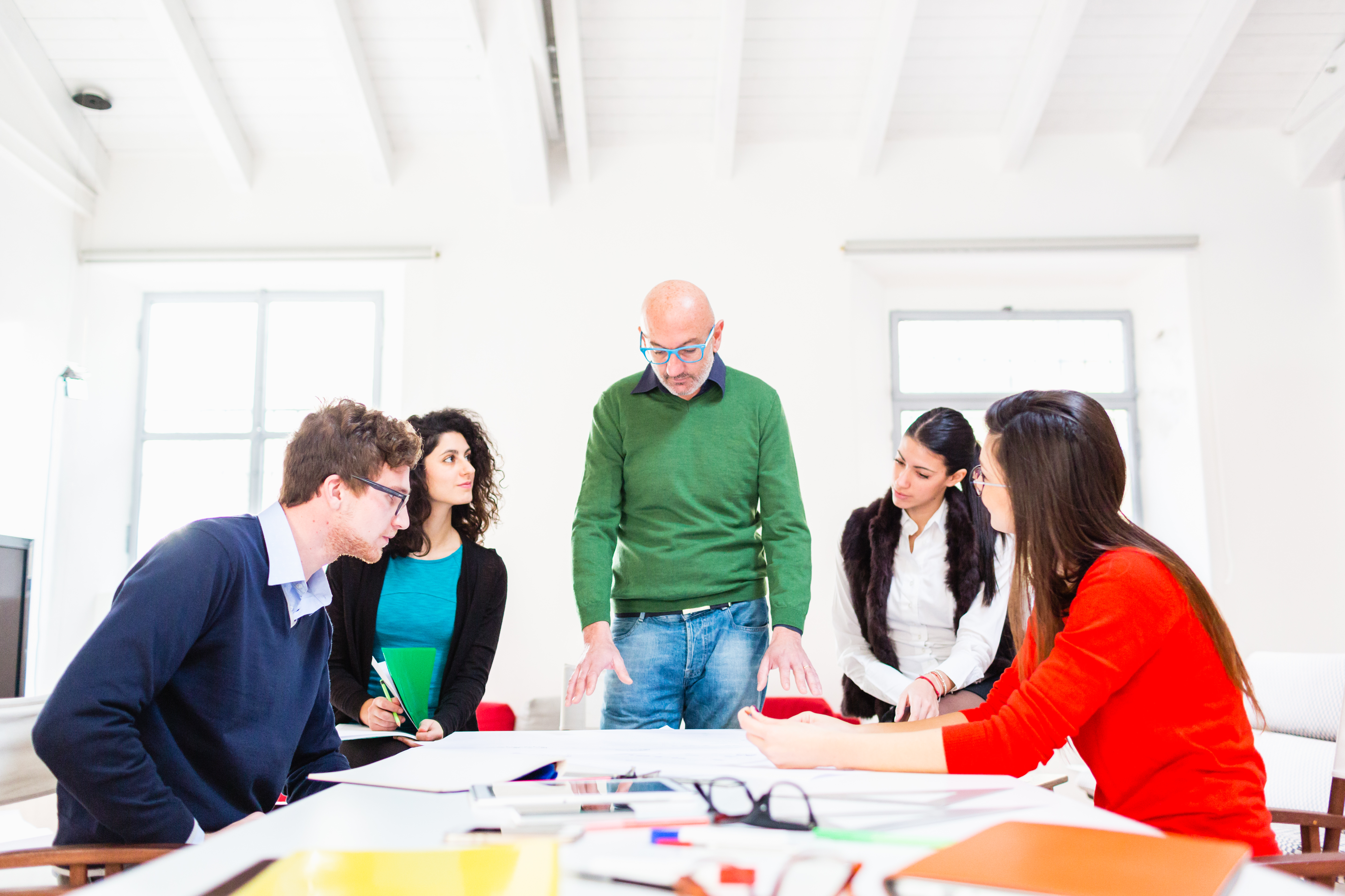 A group of creatives discussing a project around a table.