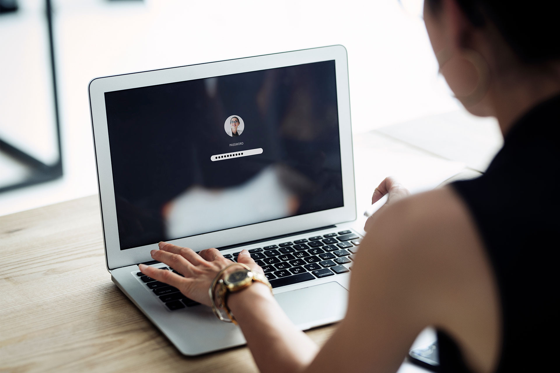 A person inputting their password to log in to a laptop