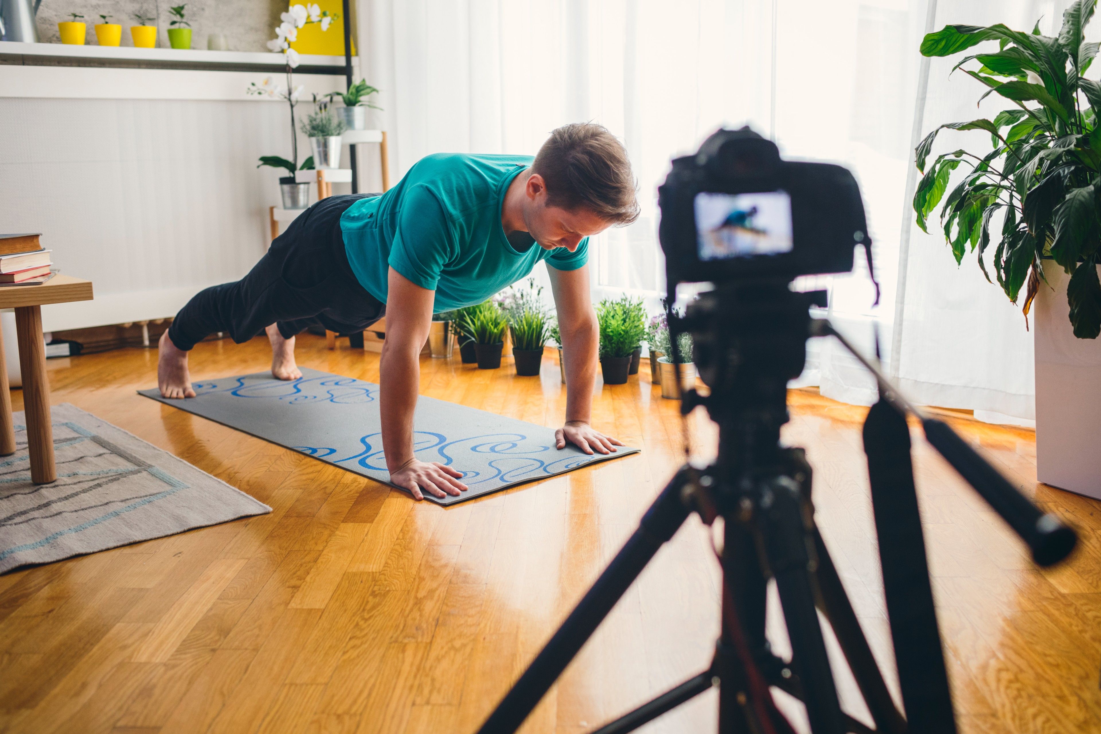 Instruktor fitness nagrywa film do swojego programu treningowego online.