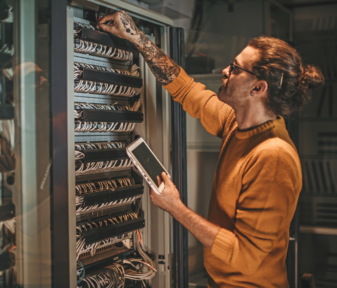 Een persoon controleert het serverrack in een beveiligd datacenter.