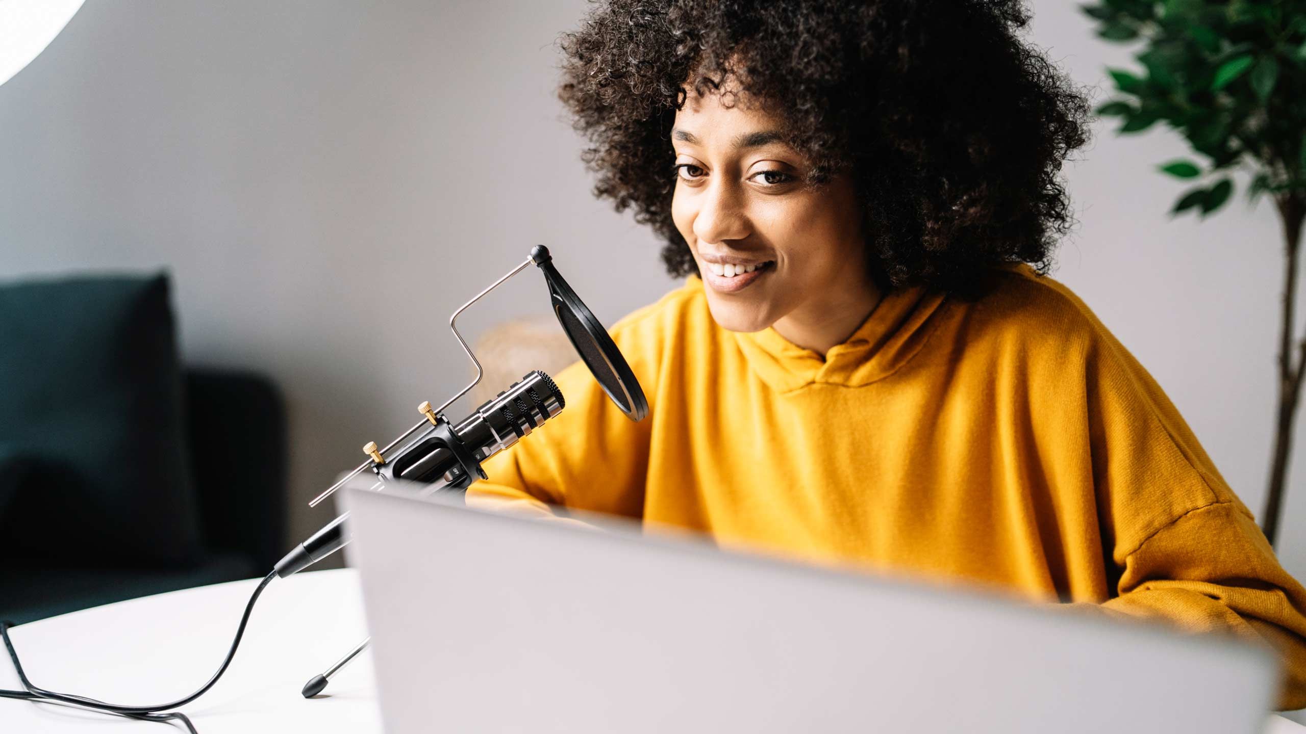 En kvinne snakker i en mikrofon på datamaskinen