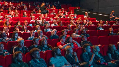 Люди сидят в переполненном кинотеатре
