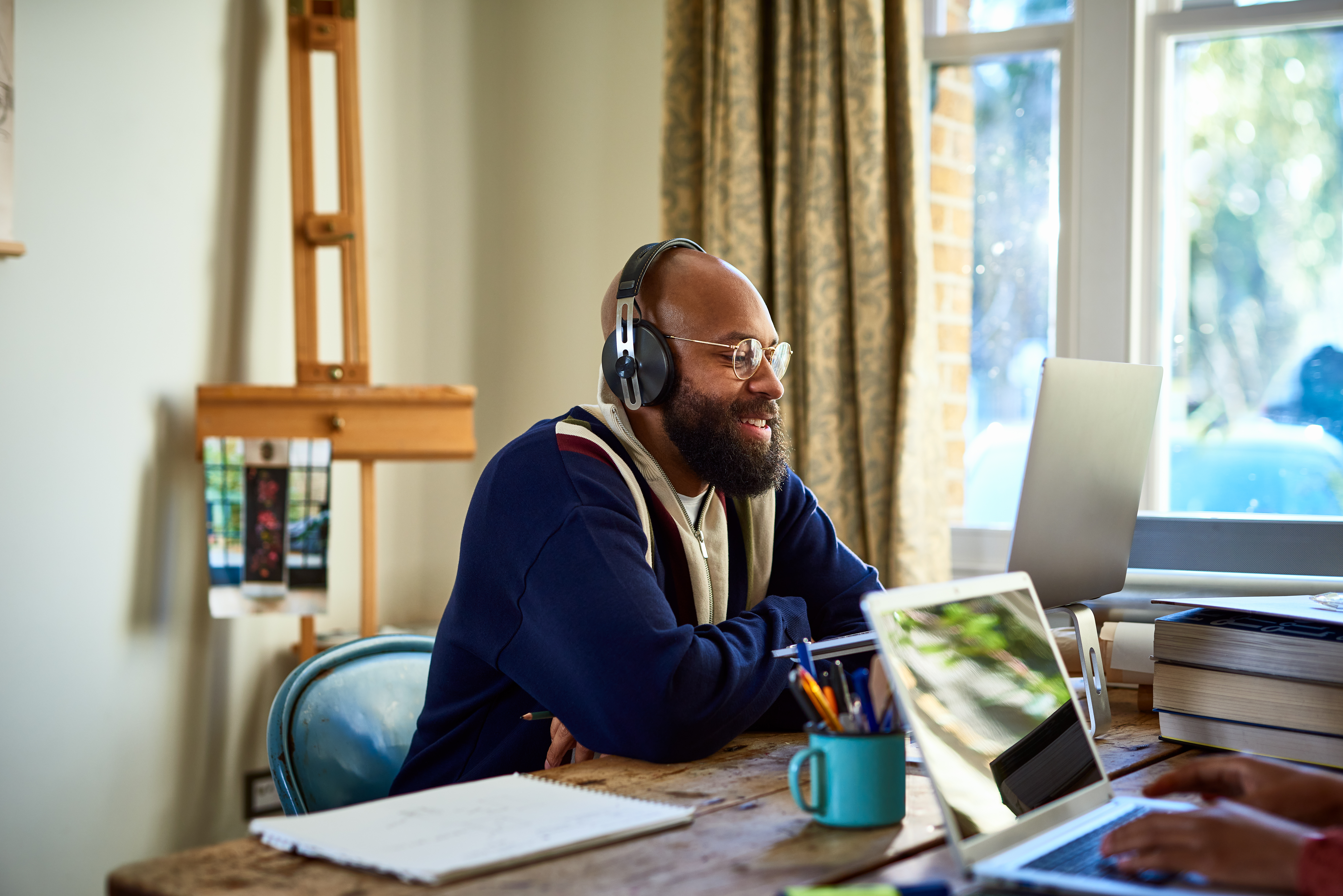 A remote professional smiles at their laptop.