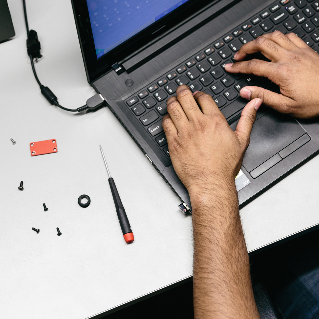 Händer som skriver på en bärbar dator med verktyg bredvid